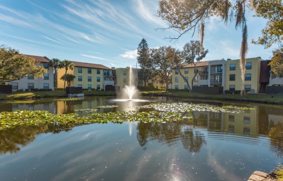 Belara Lakes Apartments exterior view with trees and lake in Tampa, FL