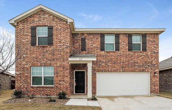 the front of a brick house with a white garage door
