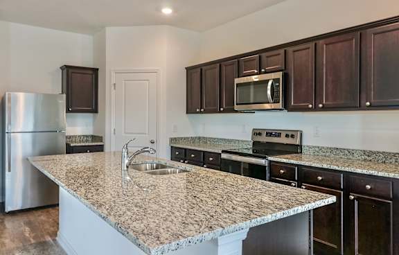 A kitchen with granite countertops and stainless steel appliances.