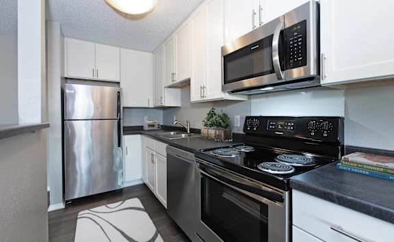 a kitchen with stainless steel appliances and white cabinets