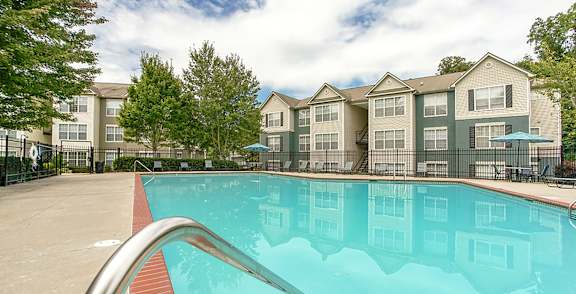 A swimming pool in front of apartment buildings.