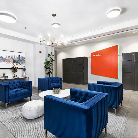 A room with blue chairs and a chandelier.