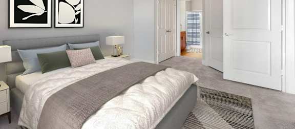 A living room with a white sofa, green chairs, and a television. at The Villagio Apartments, North Carolina, 28303
