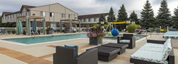 a swimming pool with lounge chairs in front of a building at Village Club of Rochester Hills, Shelby Township, MI 48317