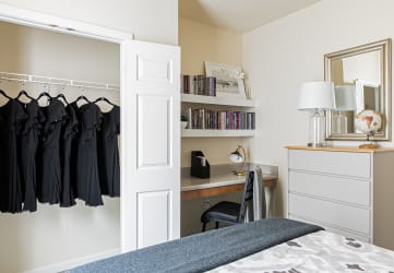 a bedroom with a closet and a desk with a chair