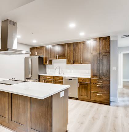 A modern kitchen with wooden cabinets and a white countertop.