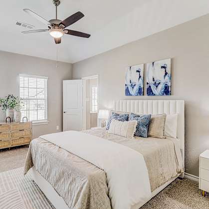 a bedroom with a large bed and a ceiling fan