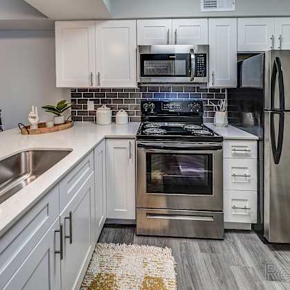 a kitchen with stainless steel appliances and white cabinets