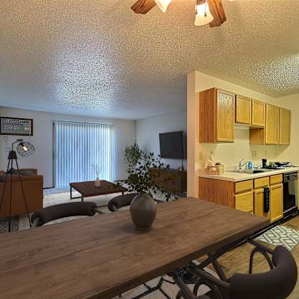 an open living room with a dining room table and a kitchen. Fargo, ND Chestnut Ridge Apartments