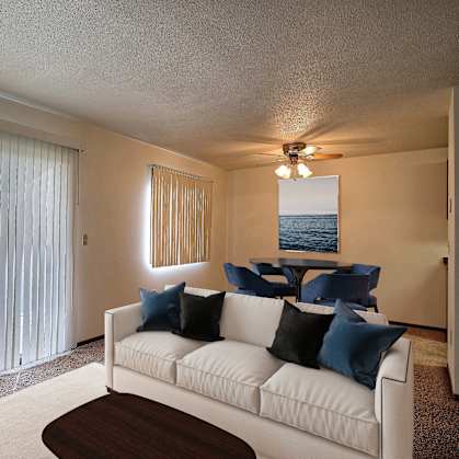 a living room with a white couch and a large window. Fargo, ND Pacific South Apartments