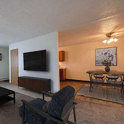 Fargo, ND Parkwest Gardens Apartments. a living room filled with furniture and a flat screen tv