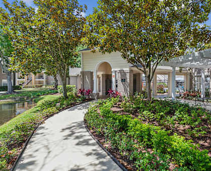 a walkway with trees and a building in the background