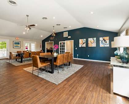 a dining room with a table and chairs and a blue accent wall