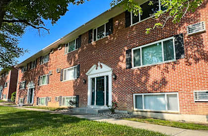 a red brick apartment building with a green door