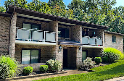 a brick house with a balcony and a lawn  at Devou Village, Ft. Wright, 41011
