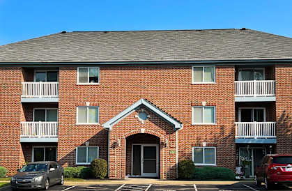 a brick apartment building with a car parked in front  at Walton Ridge Apartments, Kentucky
