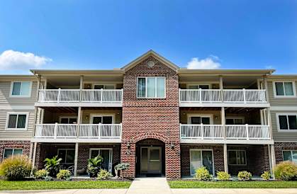 a red brick building with balconies and a sidewalk  at The Overlook at Ft. Thomas, Ft. Thomas, KY