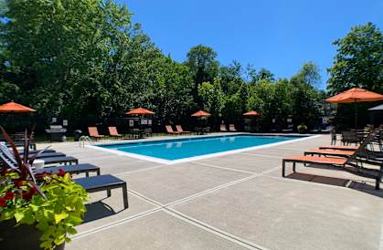 a swimming pool with chairs and umbrellas around it at Fox Run Apartments, Cincinnati