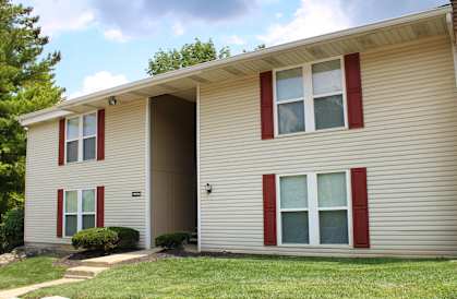 the exterior of a yellow house with red shutters and a lawn  at Timber Ridge Apartments, Cincinnati