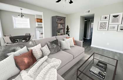 a living room with a gray couch and a glass coffee table