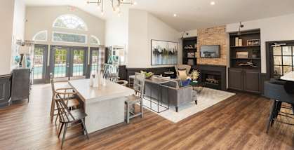 A modern open concept living room with a dining area and a fireplace.