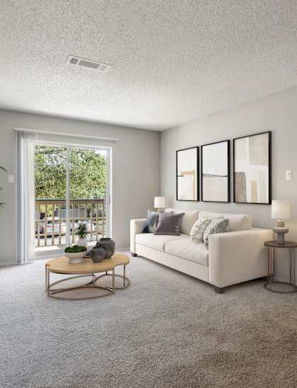 A living room with a couch, a coffee table, and a potted plant.