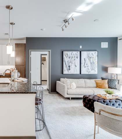 a kitchen and living room with stainless steel appliances at Dartmoor Place at Oxford Square Apartments, Hanover, Maryland