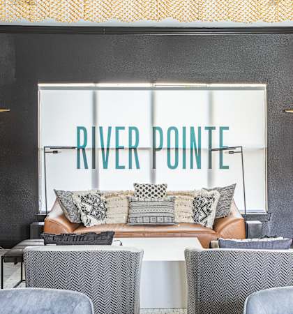 a living room with a couch and chairs and a river point window