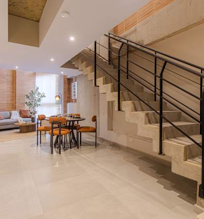 A modern home interior with a staircase and a dining table.