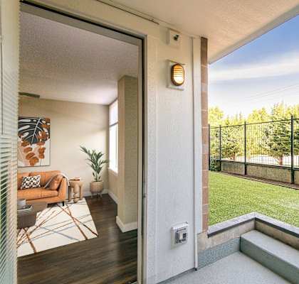 A balcony with a black railing and a small garden area.