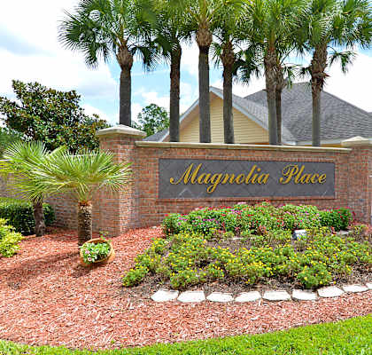 The image shows a sign that reads "Mayflower Place" in front of a house with a garden.