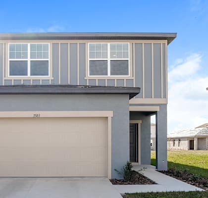 A modern house with a garage door and a driveway.