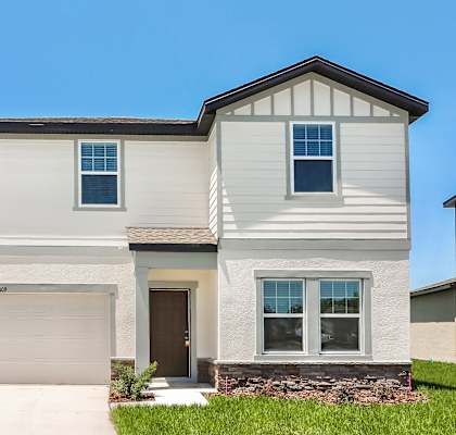 A two-story house with a garage and a brown door.