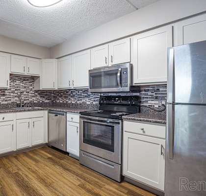 Kitchen with white appliances and wooden floors at Summit Terrace, South Portland, 4106