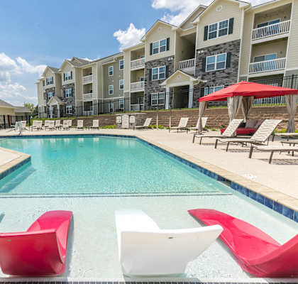 our apartments offer a swimming pool with red and white chairs at Aventura at Maryland Oaks, Missouri, 63146