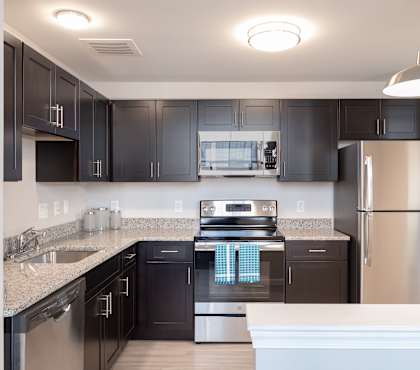 a large kitchen with stainless steel appliances and granite counter tops at Cherry Street Lofts in Bridgeport, CT, 06605