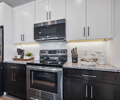 A modern kitchen with a stainless steel refrigerator, oven, and microwave.