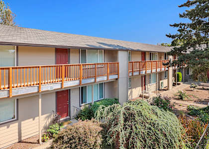 A row of apartment buildings with balconies and red doors.