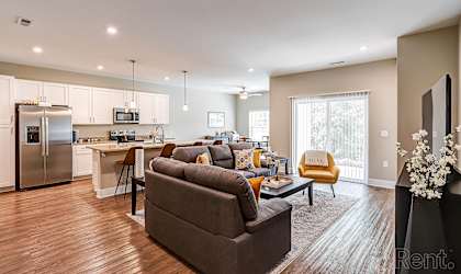 A modern living room with a grey couch and a wooden floor.
