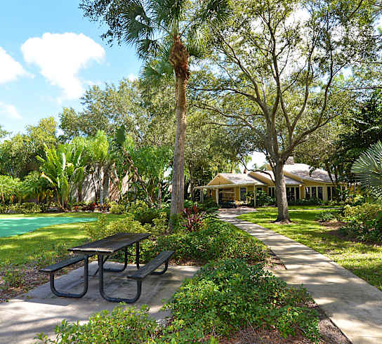 a picnic table in a park next to a pool