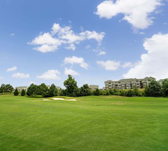 A golf course with a building in the background.