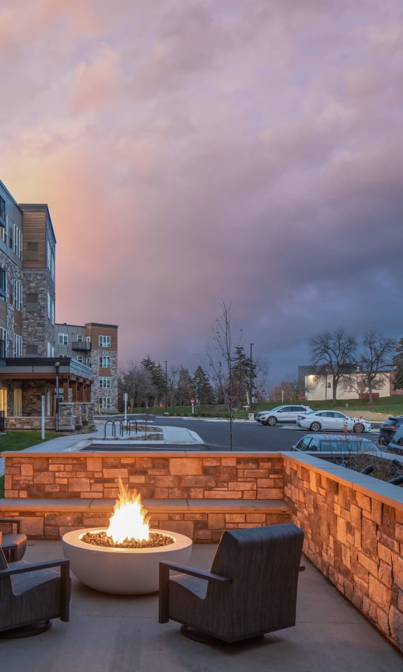 an outdoor patio with a fire pit at dusk