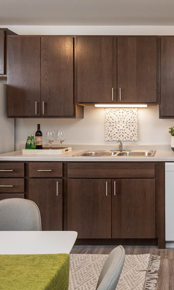 A modern kitchen with brown cabinets and white appliances.