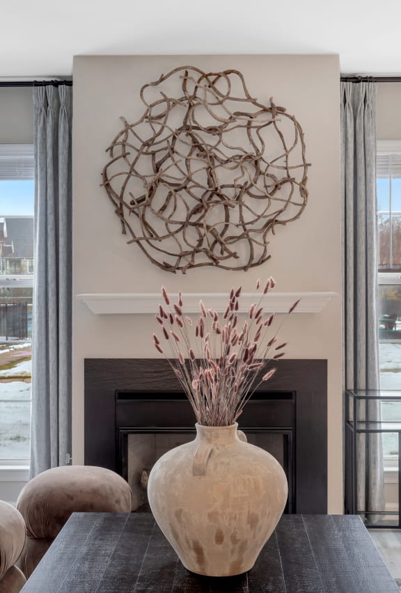 a living room with a fireplace and a large vase at The Austin Apartment Homes, New Jersey, 08096