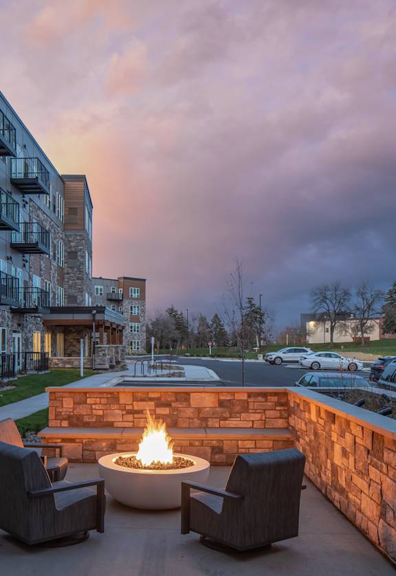 an outdoor patio with a fire pit at dusk
