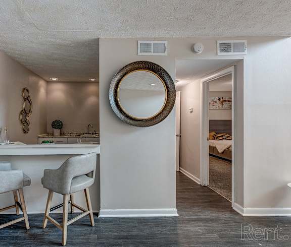 a kitchen with stools and a counter with a mirror