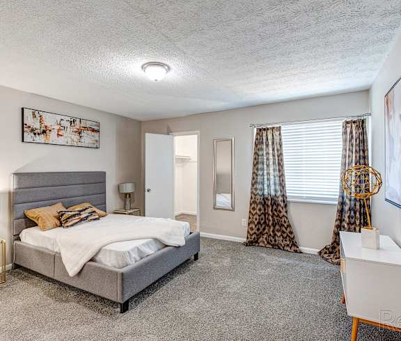 a bedroom with a bed and a window with curtains