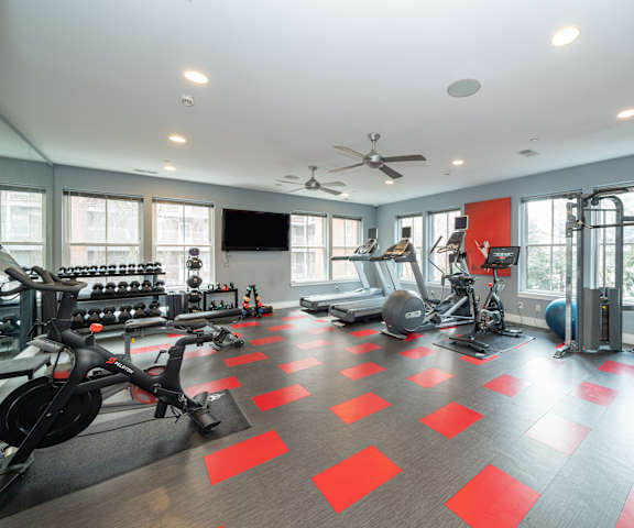 the gym has plenty of exercise equipment and windows