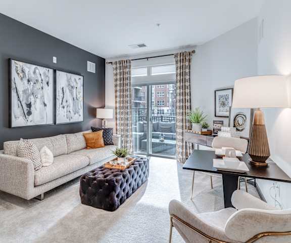 a living room with a couch and a chair and a table at Dartmoor Place at Oxford Square Apartments, Hanover, Maryland