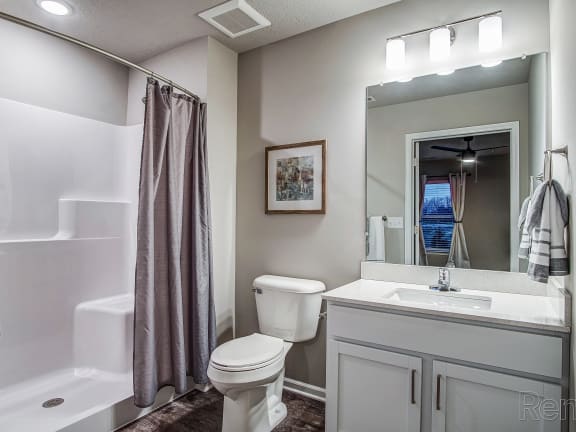 a bathroom with a shower toilet and sink and a mirror